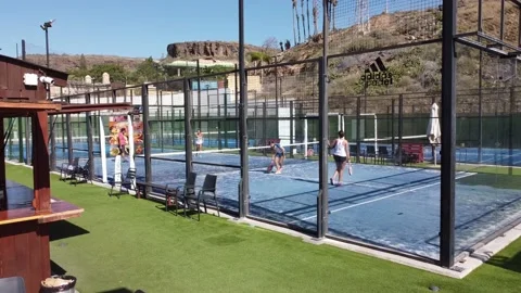 Back view of female padel player hits the ball with a racket. Torneo padel 4k Stock Footage 233299076