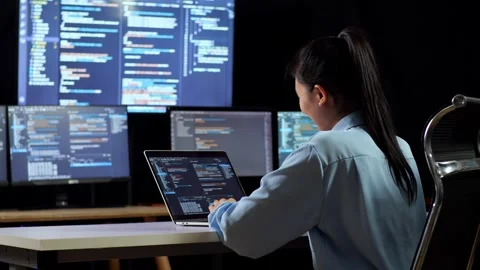 Back View Female Programmer Writing Code Laptop Using Multiple Monitors Stock Footage 244423958