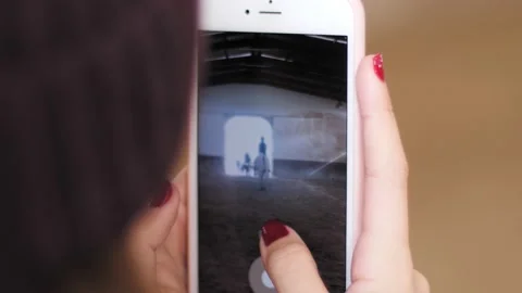 Back view of female with red nails making video with phone at dressage contest. Stock Footage 151322242