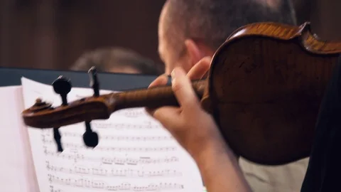 Back view of a female violinist`s hand playing the violin in the orchestra Stock Footage 89946399