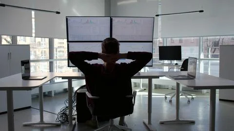 Back view of financial advisor work at multi-screen workstation and relax Stock Photos