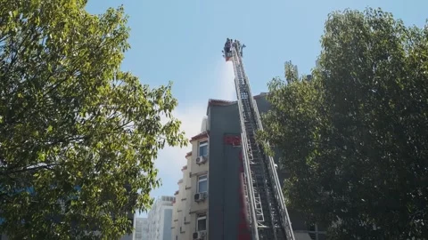 Back view of firefighters in elevated platform extinguish burning house using Stock Footage 282380759