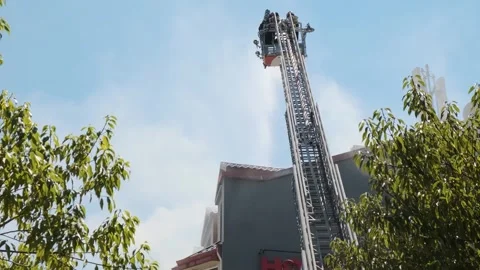 Back view of firefighters in elevated platform extinguish burning house using Stock Footage 282813334
