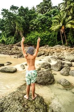 Back view of five year old toddler boy playing at the tropical. Summer fami.. Stock Photos
