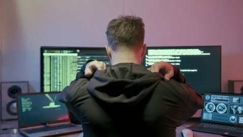 Back View Of Focused Male Programmer Puts On Hood While Typing Lines Of Stock Footage 237494034