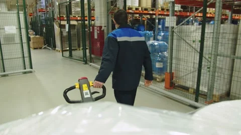 Back view of forklift operator in special uniform pulling the batch of packaged Stock Footage 200855785