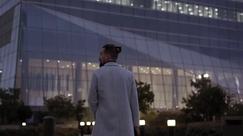 Back view formal man walking illuminated business center. Young successful Stock Footage 248052567