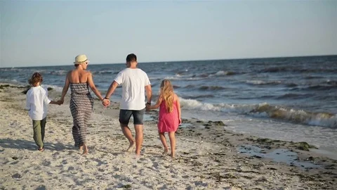 Back View of Four Members of Happy Family Walking on the Beach During Summer Stock-Footage 82166309