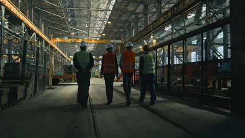 Back view of four technicians discussing production, walking at plant Stock Footage 280437020