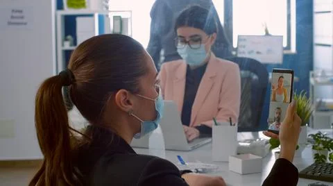 Back view of freelancer man with face mask talking on videocall meeting 스톡 사진