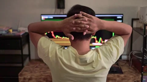 Back view of frustrated trader with hands on head, financial charts showing Stock Footage 342748186