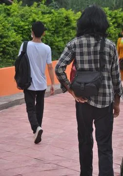 Back view full length of two young guys  walking in outdoor  Stock Photos