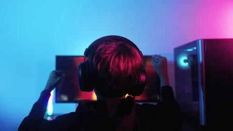 Back view gamer playing and celebrating video game e-sport victory at gaming  Stock Footage 260908015