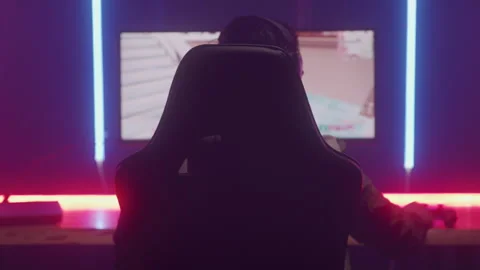 Back View of Gamer Putting on Headset Getting Ready to Play Game on Computer Stock Footage 208775250