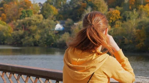 Back view of girl drinking coffee from paper cup and talking on phone. Stock Footage 119831748