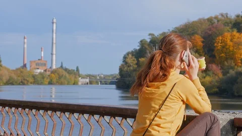 Back view of girl drinking coffee from paper cup and talking on phone. Stock Footage 119831783