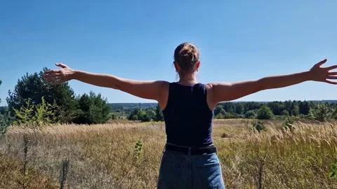 Back view of a girl spreading her arms wide towards nature Vídeo Stock 345238546