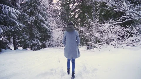 Back view of girl walking into deep forest in big snow Stock Footage 125042746