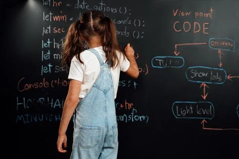 Back view of girl write the code about getting time on blackboard. Erudition. Stock Photos