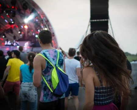 Back view of group of dancing people on the dance floor at music festival Stock Photos