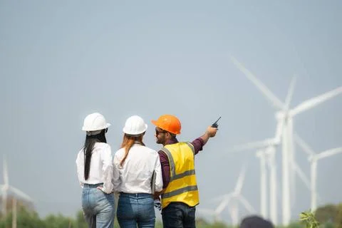 Back view of group engineers and architects on construction site with wind... Foto stock
