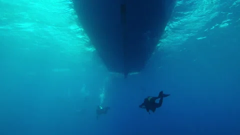 Back view of group of scuba divers swimming in turquoise water towards diving Stock Footage 318044478