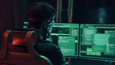 Back view of guy using futuristic headset with LED lights programs develops code Stock Footage 219347450