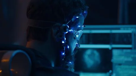 Back view of guy using futuristic headset with LED lights programs develops code Stockfoto's