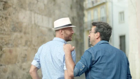 Back view of guy walking and putting hand on boyfriends shoulder Stock Footage 164739355