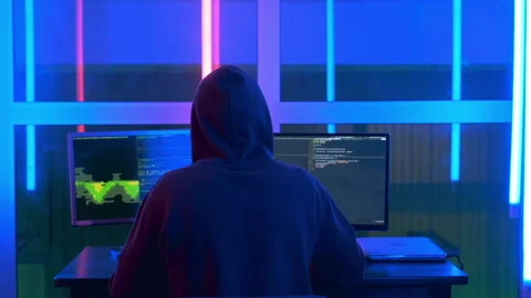 Back view of hacker in a black jacket and a hood on his head, writing hacker Video stock 154714905