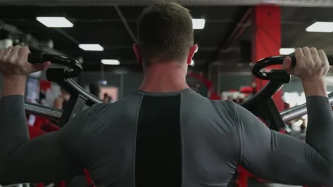 Back view of handsome athletic man performing press on Strength Trainer machine Video stock 143522386