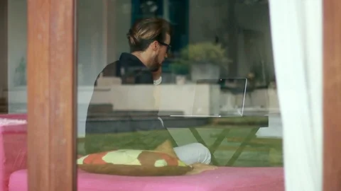 Back view of handsome young man finishing talking on the mobile phone and Stock-Footage 85523897