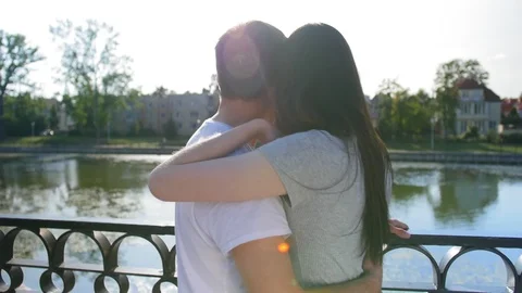Back view of happy couple standing and looking into the pond, outdoor in the Stock Footage 116671477