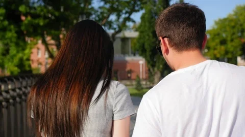 Back view of happy couple walking outdoor and talking together in park. Couple Stock Footage 116663469