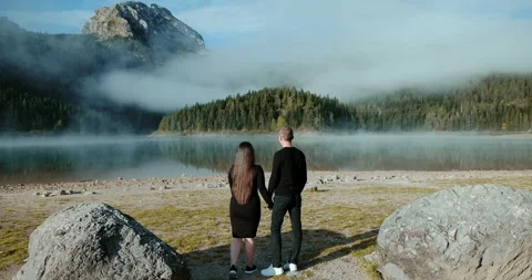 Back view of  happy lover in wild nature, young couple standing Stock Footage 130363754