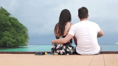 Back view of happy romantic couple of man and woman sitting together in pier Stock Footage 164238758