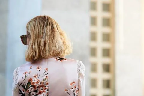 Back view head and shoulders of woman in silk floral dress 스톡 사진