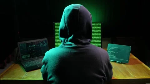 Back view of hooded computer hacker sitting at dark room Stock Footage 280178926