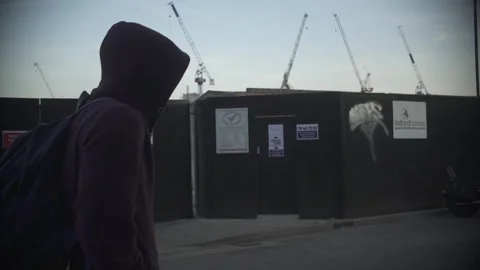 Back View of Hooded Person Walking on Urban Street 動画素材 344625709