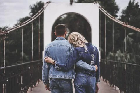 Back view of hugging couple staying on the bridge and enjoying rest Foto stock