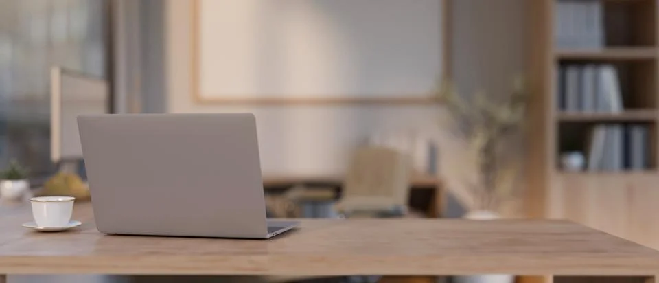Back view image of a laptop computer on a wooden table in a modern, minimal.. Ilustración de archivo