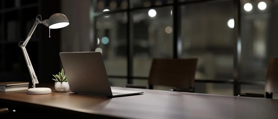 A back view image of a laptop computer on a meeting table in a modern dark .. Stock Photos