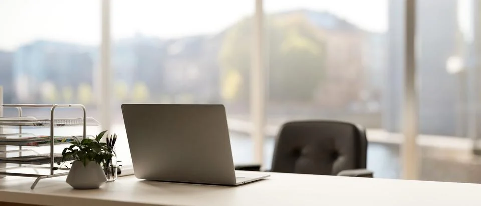 Back view image of a modern minimal bright office with a laptop computer on.. Ilustración de archivo