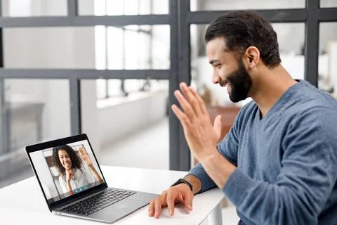 Back view of Indian man making video call with his female friend Stock Photos