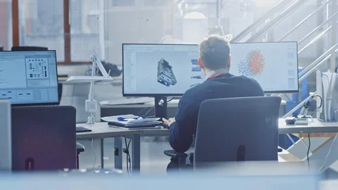 Back View of Industrial Engineer Working on Desktop Computer in Bright Office. Stock Footage 105358893