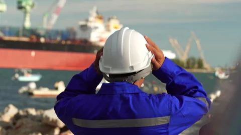 Back view of industrial worker in blue uniform wearing white safety helmet Stock Footage 342918235