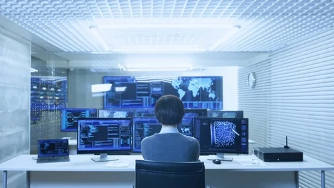 Back View of the IT Engineer Working with Multiple Monitors Showing Graphics. Stock Footage 80978487