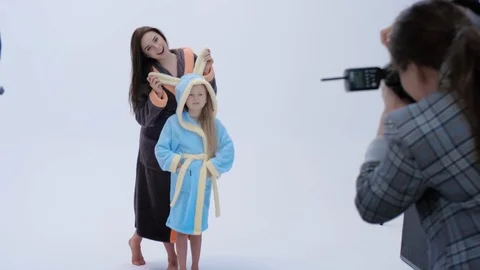 Back view of lady with photo camera taking pictures of cheerful mother and Vidéo 122432425