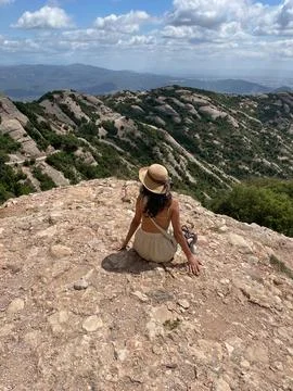 Back view of a lady sitting and enjoying the mountain view Stock Photos