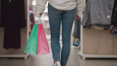 Back View of Lady Walking in Retail Store with Colorful Shopping Bags Stock Footage 300100695
